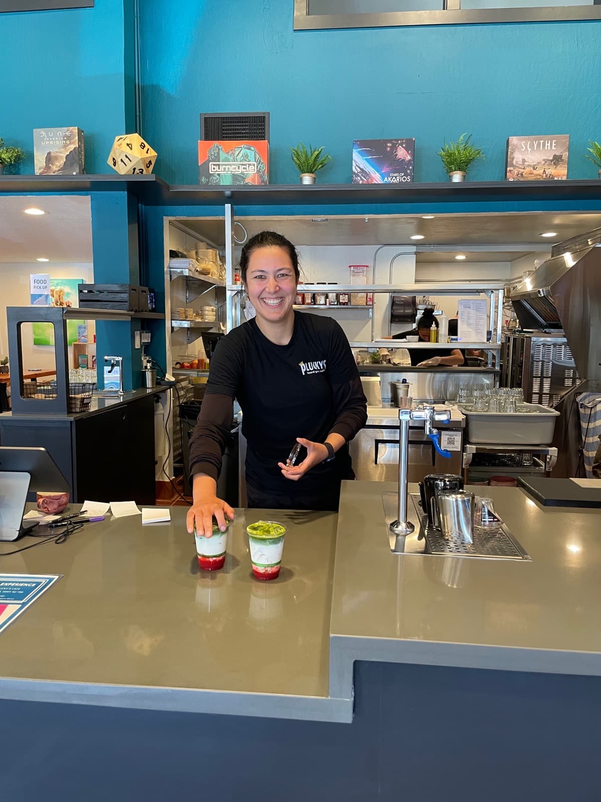 Serving two strawberry matcha drinks at the counter