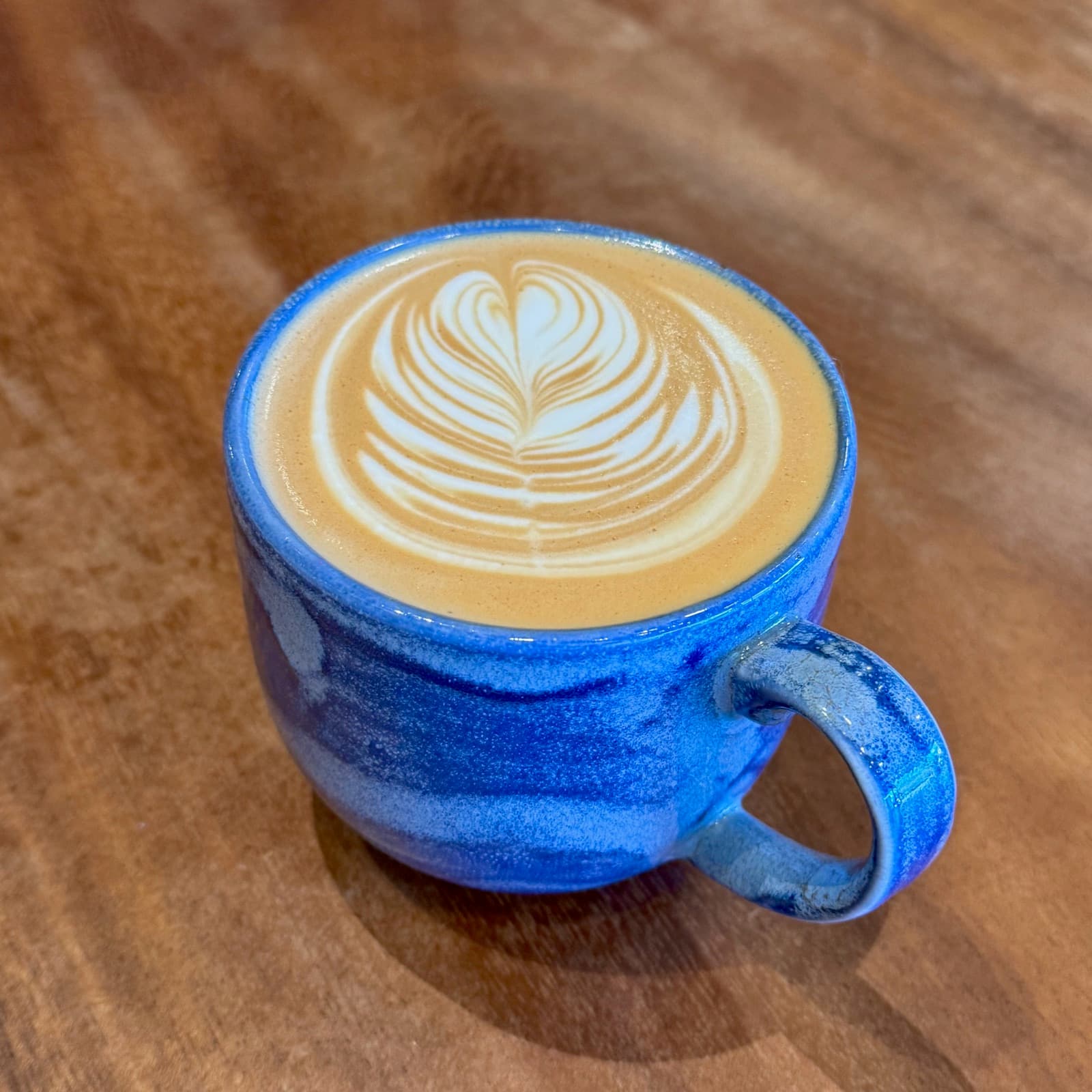 Latte with heart rosetta in a blue mug